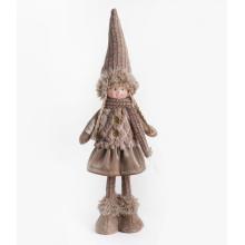 TEXTILNÉ DIEVČA, STOJACE, V HNEDÝCH ŠATÁCH, S KLOBÚKOM NA HLAVE