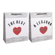 PAPIEROVÁ TAŠKA S MATNOU KLOPOU SO STUHOU, ČIERNY MEDZINÁRODNÝ NÁPIS NA BIELOM POZADÍ, "A LEGJOBB MAMA/ THE BEST GRANDMA" S ČERVENÝM SRDCOM