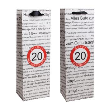 PAPIEROVÁ TAŠKA S VÍNOM, MATNÁ, S CHLOPŇOU SO STUHOU, ČIERNA NA BIELOM POZADÍ, S NÁPISOM "HAPPY BIRTHDAY" V NIEKOĽKÝCH MEDZINÁRODNÝCH JAZYKOCH NA POZADÍ, ČERVENÝ KRÚŽOK S ROKOM "20"