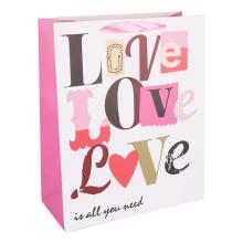 PAPIEROVÉ VRECKO S MATNOU, STUŽKOVOU CHLOPŇOU, BIELE POZADIE S NÁPISOM LOVE/LOVE/LOVE