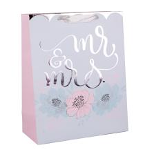 PAPIEROVÁ TAŠKA S MATNOU STRIEBORNOU POTLAČOU, S CHLOPŇOU SO STUHOU, MODRÝM A RUŽOVÝM KVETINOVÝM VZOROM NA SIVOM POZADÍ, S PÁNOM A PANI.
